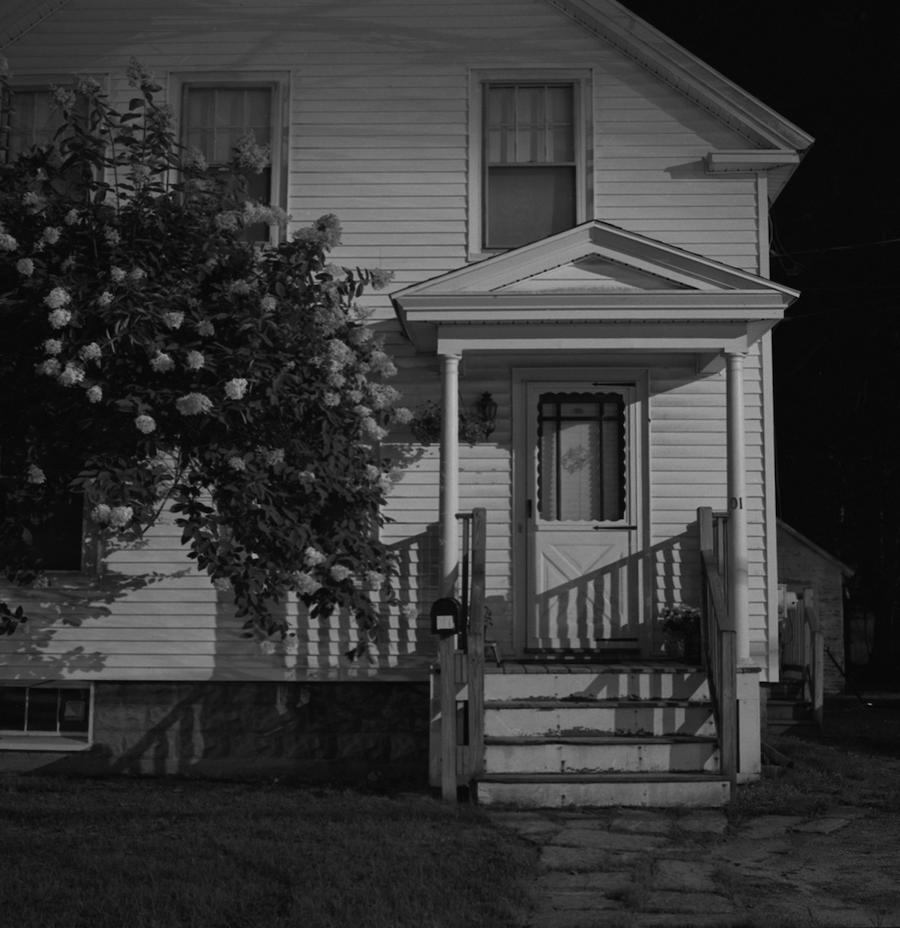 A black-and-white untitled print of the front of a house from Chris Zhang's Midnight Penumbra show